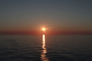 Obraz premium Sunset over calm water. Golden sun, tranquil scene