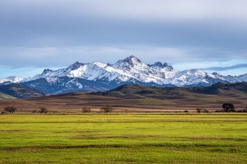 Snowy peaks rise above a vibrant valley