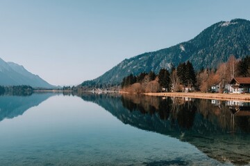 Fototapeta premium Calm lake reflecting mountains and houses