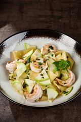 Shrimp pasta with zucchini, moody lighting, overhead composition