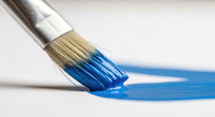 Paintbrush Applying a Stroke of Vibrant Blue Paint on White Surface, Close-Up