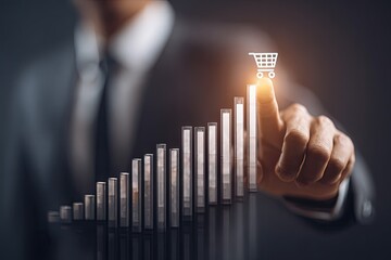 Businessman's finger pointing at a rising bar graph with a shopping cart icon, signifying growth and sales