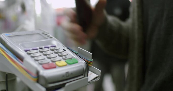 paying through smart phone using NFC technology. Close-up. 4K modern technology cafe shopping fashion green string counter