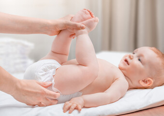 mother changing baby's diaper. baby care concept
