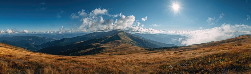 Obraz premium Panoramic view of mountain peaks and valleys under a vibrant sky. Golden-toned meadows stretch across the foreground, leading to rugged, 