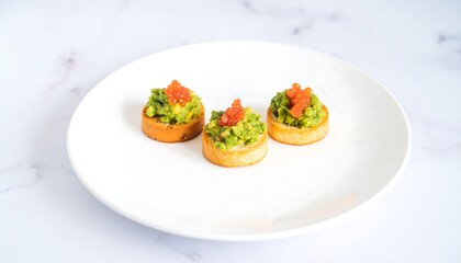 Small, round avocado toast appetizers on a white plate