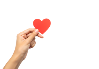 Close-up of a hand holding a red paper heart symbolizing love and compassion against a black