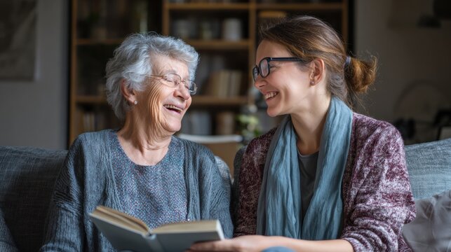 Elderly Woman Laughing with Caregiver While Reading Together - Powered by Adobe