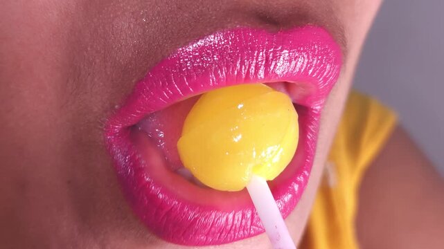 Lollipops, Female mouth licks sweet stick candy. Sexy Indian girl eating popsicles or chupa chups close-up. Woman lips sucking Tootsie Pops. Sensual sex shop concept. Sexual dreams. Pleasure. 