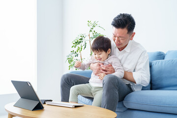 Fototapeta premium テレワークする父親を邪魔する子ども
