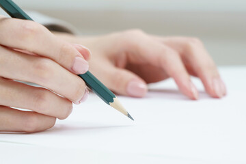 鉛筆を持つ女性の手