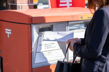 請求書を郵送するスーツの女性