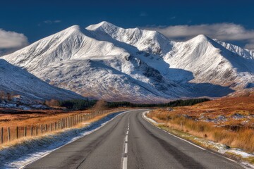 Snowy mountain range with a road winding through