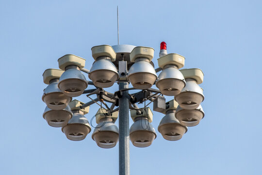 Multiple overhead spotlights mounted on tall metal pole used for public lighting in open areas, Zapopan, Jalisco, Mexico