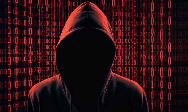  Hacker silhouette on a computer screen made of binary code, against a background.
