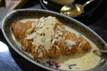 Oum Ali is a combination of a croissant sprinkled with various crunchy nuts, raisins and drizzled with spiced milk.
