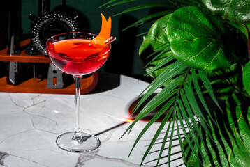 Red alcoholic cocktail drink with bitters, juice, prosecco sparkling wine and orange zest
