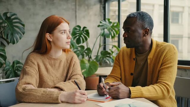Young adults engaging in creative discussion at workspace with multiracial collaboration
