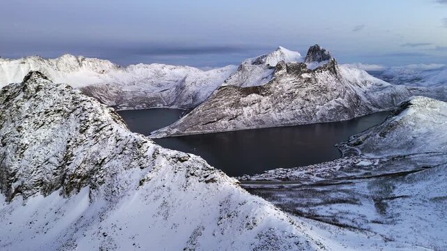 Cinematic aerial view of Hesten, one of the most photographed peaks on Senja Island, Norway, its horse-like shape towering over fjords and rugged Arctic landscapes in Troms og Finnmark County