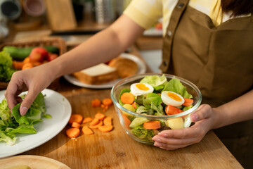 Close up of woman cooking healthy foods in kitchen in morning at home.