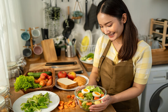 Asian young woman cooking healthy foods in kitchen in morning at home. 