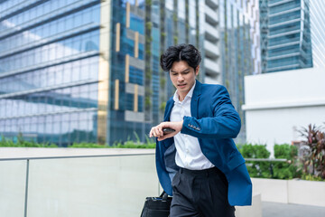 Asian young busy businessman running late to the office workplace.