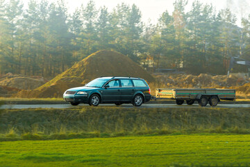 Black estate car towing covered trailer