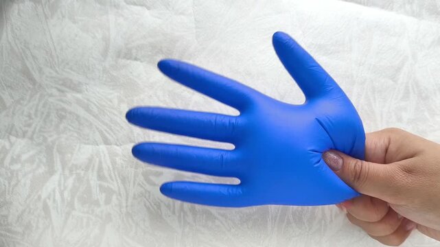 An inflated blue medical glove in the doctor's hand. The concept of the medicine festival. International Day of the Doctor, Nurse.