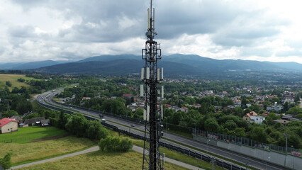 Obraz premium Telecommunications tower and town landscape in mountains