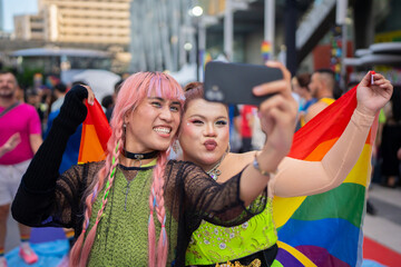 Young LGBTQ people taking a selfies in pride parade during Pride Month.