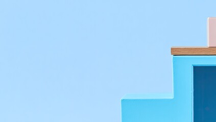 Light blue and light pink blocks create a simple, geometric, tiered platform against a pale blue backdrop