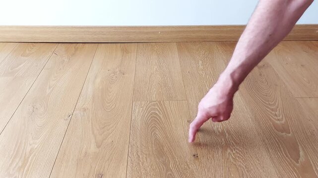 Watch as tiny fingers dance across a sunlit wooden floor, creating a playful rhythm in this quiet, intimate moment. The gentle taps and skips evoke childhood curiosity and simple joys