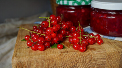Rustic arrangement of homemade red currant jam jars by some fresh currant berries. Homemade preserves and natural ingredients with by traditional recipes. 