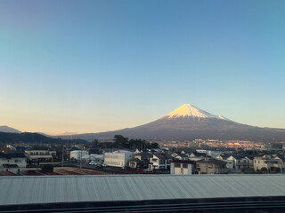 新幹線の窓から見えた富士山と住宅街のある夕方の風景