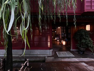 雨あがりの東茶屋街の赤い建物の入口