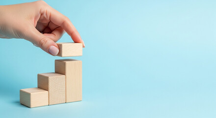Business Growth and Success Process &mdash; Woman&rsquo;s Hand Arranging Wooden Blocks as Step Stair on Blue Background with Copy Space