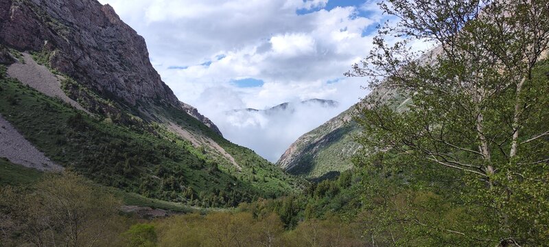 Beautiful clouds descend into the valley. Sairam-Su Gorge, Sairam - Ugam National Park, Turkestan region, Republic of Kazakhstan.