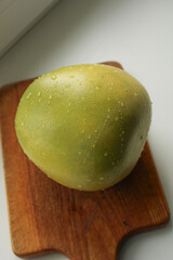 Fresh red green pomelo fruit with water drops on wooden cutting board white background