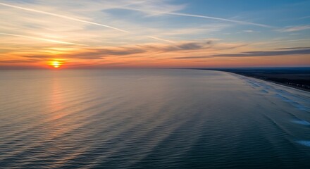Fototapeta premium Golden hour over the ocean at the beach, a serene seascape at sunset offering a peaceful