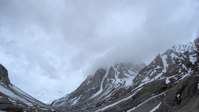 snow covered mountains and a sky full of clouds, how the landscape looks like just before the heavy rain on the snowy mountains in the stomy weather conditions  
