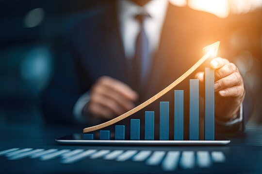 Businessman points to a rising graph on a tablet