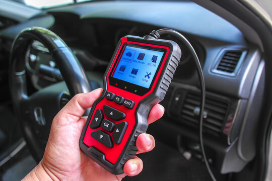 OBD2 scanner in hand, car diagnostic tool and code reader to check engine light, read and clear DTCs, view live data and voltage, automotive repair and maintenance