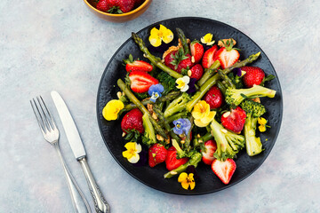 Salad of green asparagus, strawberries and pine nuts.