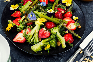 Salad of green asparagus, strawberries and pine nuts.