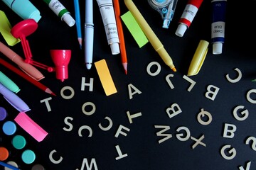 Flat lay composition of colorful school and art supplies arranged around a small easel with a blank canvas, set on pastel-colored paper background. Ideal for themes of back to school, creative