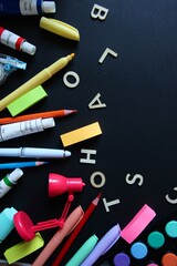 Flat lay composition of colorful school and art supplies arranged around a small easel with a blank canvas, set on pastel-colored paper background. Ideal for themes of back to school, creative