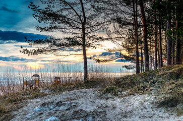 Sunset above Baltic Sea. Winter coastal landscape with pine forest and sand dunes in Jurmala tourist resort, Latvia