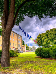 Public park near president palace with waiving flags of Latvia, European Union and Ukraine near façade of governmental buildings, historic  center of old Riga city - the capital of Latvia 