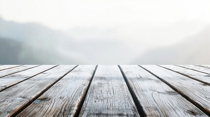 A wooden table with a white, blurred background of mountains and fog.