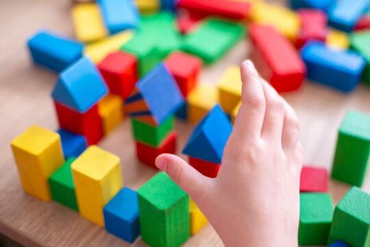 Child fun playing with wooden toys, play time, Colorful blocks and figures on table. Early education, fine motor skills concept